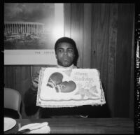 Muhammad Ali holds up a birthday cake
