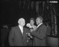 Archie Moore tests the biceps of Casey Stengel