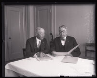 W. Freeland Kendrick and James R. Watt looking at documents while sitting at table, Los Angeles, 1931