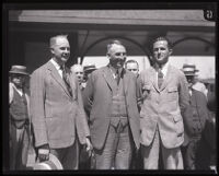 National Commander John R. Quinn stands with two men, possibly at a train station, Los Angeles, 1924