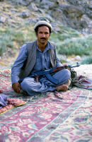 Mujahid Sits With Their Gun in Carpet