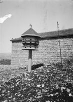 General view of a bird house with part of a building visible in the background