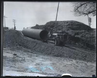 Tractor moving pipe in reconstruction after flooding caused by the collapse of the Saint Francis Dam, Santa Clara River Valley (Calif.), 1928