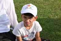 A young boy wearing a cap with a motto, " Yes for Kurdistan Independence"