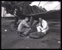 Henry Du Pont changes his airplane's tire with friend John W. Beretta, Montebello, 1927