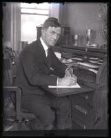 Playground Superintendent Charles B. Raitt writes at his desk, Los Angeles, 1925