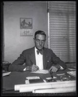 Director of city airports Richard Barnitz writing at his desk, Los Angeles, 1930