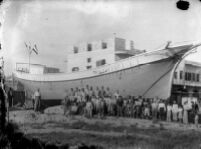 A group of men posing in front of a newly built ship
