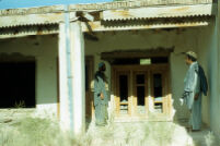Two Mujahid Stands in The Courtyard of House
