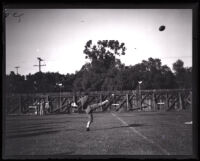 Bill Cook, USC football player, punting a football, Los Angeles, 1925-27