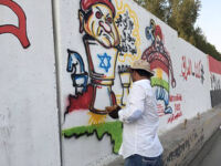 Graffiti of Masoud Barzani as a wind-up toy in Israel's hand