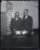 Undersheriff Frank Dewar and man holding a box, Los Angeles, 1930s