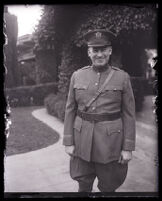 John R. Quinn in his military uniform smiling at the camera in front of his home, Los Angeles, 1929