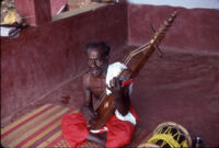Mannān Velayudhan singing as he plays a naṇduni at the home of Chummar Choondal, Chettupuzha (India), 1984
