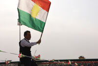 A young man waving a Kurdish flag