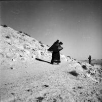 Bedouin woman carrying a ghirbe filled with water