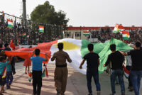 People waving a big flag of Kurdistan