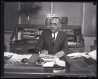 George Bierman signing papers at his desk, Los Angeles, 1926-1931