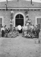 Group portrait of construction workers at the entrance of a facility