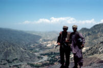 Two Mujahideen Stands With Their Guns on Top of The Mountain