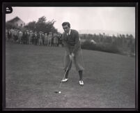 American professional golfer Johnny Farrell prepares to take a swing at a golf ball, circa 1922-1934