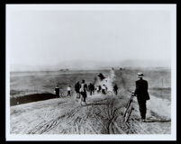 Group of bicyclists on an unpaved road in an open area, Los Angeles (?), 1880-1920