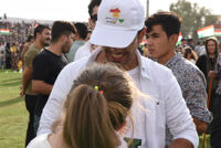 A young man wearing a white cap reading, " Yes for Kurdistan Independence"