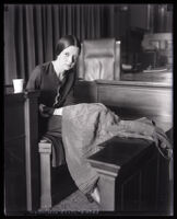 Eunice Pringle on the witness stand examining a dress during Alexander Pantages rape trial, Los Angeles, 1931