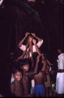 Ottan Thullal - Sethu and M. G. Shashibhooshan hold up sweets for children after the performance, Ayamkudy (India), 1984