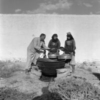 Villagers roasting grains in a cauldron