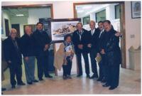 Guadalupe Kirarte Domínguez con un grupo de hombres desconocidos rodeando una pintura