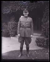 John R. Quinn in his military uniform smiling at the camera in front of his home, Los Angeles, 1929