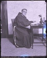 Father Superior Augustine seated at a desk at Hotel Alexandria, Los Angeles, 1925