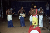 Theyyam festival - Thirayāṭṭam performer and musicians behind microphones, Kalliasseri (India), 1984