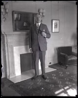 H. F. Alexander, president of Pacific Steamship Company, standing with pipe, Los Angeles, 1922-1930