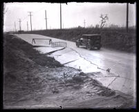 Road with broken pavement after a flood caused by heavy rain, Los Angeles, 1027