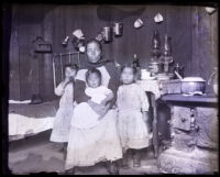 Mother and children posing in the rom of a house, San Gabriel, 1920s