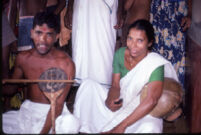Male musician with a Pulluvan vīṇā kunju, and a female musician with a Pulluvan kudam *clay "pot", Chettupuzha (?), (India), 1984