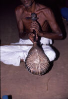 Sarpam Thullal Pulluvan Serpent Ritual - O. K. Raman holding a Pulluvan vīṇā kunju, Peramangalam (India), 1984