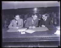 Defendents Dave Getzoff and Ben Getzoff with defense attorney Al McDonald in a courtroom, Los Angeles, 1929 