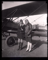 Aviation school operator Twyla J. Kelly and her son, Merle F. Kelly, pose next to an airplane, Hawthorne, circa 1929