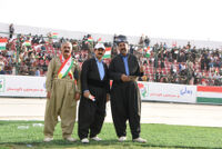 Three men wearing Kurdish clothing
