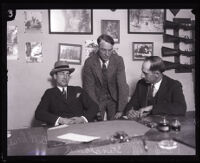 Sidney Blair and Los Angeles Deputy Sheriffs Frank Dewar and Norris Gilbert Stensland seated at a desk, Los Angeles, 1924