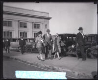 Editor and author Edward Bok walking down a street with two women, Los Angeles, circa 1920s