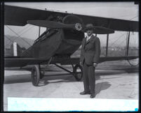 Assistant secretary of war F. Trubee Davison standing in front of a biplane, Los Angeles, 1920s