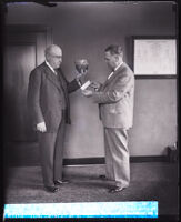 School superintendents Frank A. Bouelle holding a bowl and H. S. Upjohn drawing slips, Los Angeles, 1929