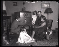 Mayoral candidate John R. Quinn listening to the radio at home with his wife and children, Los Angeles, 1929