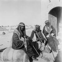 Outdoor portrait of Bedouins sitting on wheat bags
