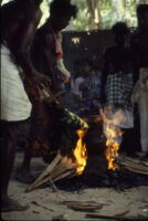 Villupāttu event - ritualist tends a fire for a manjal nirattam trance ritual with the pancu medium behind him at the Ayyappan Temple, Achankulam (India : Village), 1984