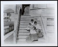 Nella Allensworth and three others seated on the front steps of a house, circa 1900